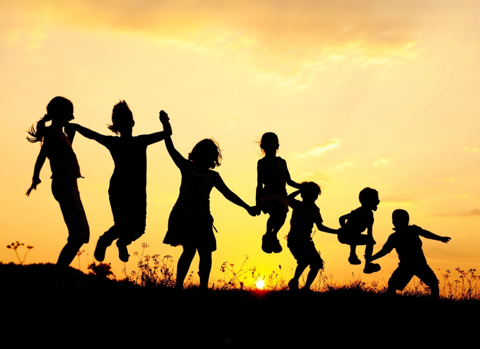 7 children silhouetted against evening sky 