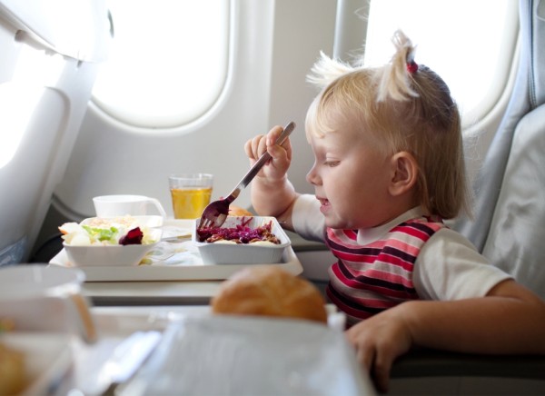 Small girl eating on an aeroplane