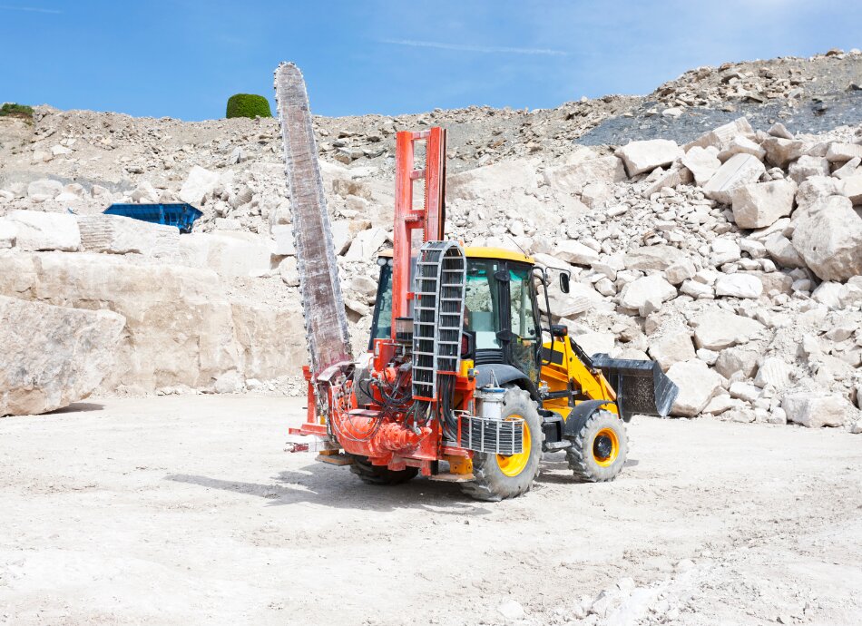 Machinery in stone quarry with rocks