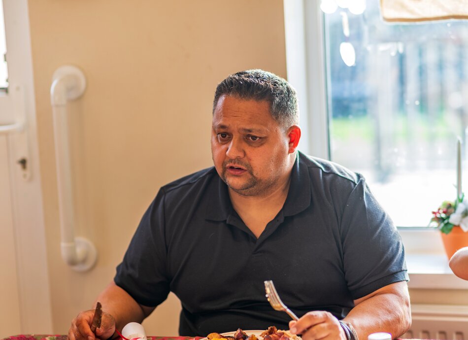 Polynesian man eating at table