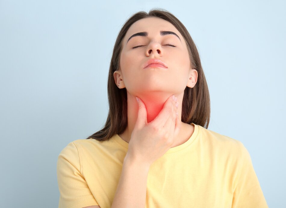  Young woman shows position of thyroid gland on her throat