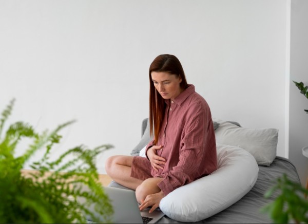 Pregnant woman looking sad with hand on tummy