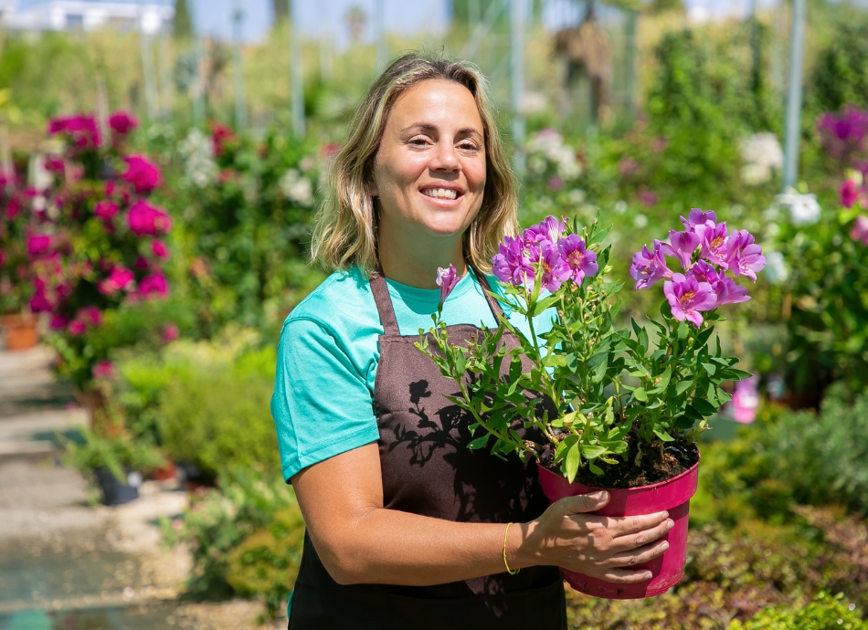 Woman holding flowering pot plant 