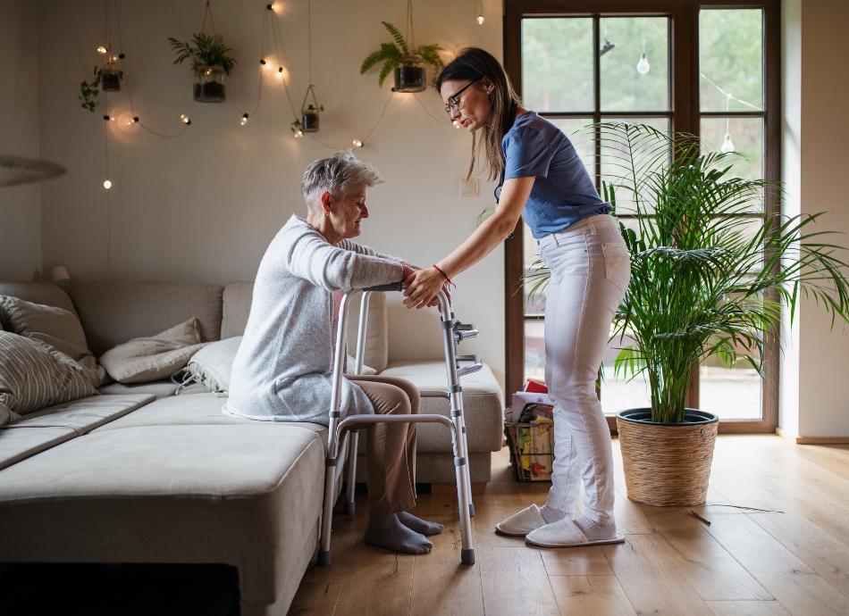 Young woman helping older woman with walker at home 